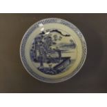 A Chinese blue and white dish decorated with figures seated under a flowering tree, 6 character mark