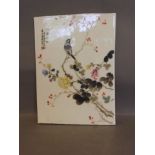 A Chinese ceramic plaque painted with a bird on a flowering branch, signed, 12½'' x 9''