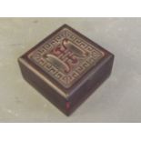 A Chinese red hardstone box with carved decoration of symbols, containing four small soapstone