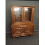 A Continental oak display cabinet with glazed upper section over two cupboards, with applied moulded