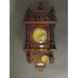 A C19th Dutch walnut wall clock with turned and moulded decoration and lacquered paper chapter