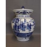 A large Chinese blue and white flared rim jar and cover decorated with flowers in an interior,