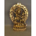 A Tibetan bronze figure of a warrior and deity standing on a beast, 9½'' high
