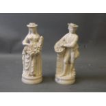 A pair of Parian style bisque figures bearing baskets of flowers and grapes, unmarked, 13'' high