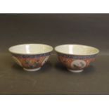 A pair of Chinese porcelain tea bowls with painted enamel foliate decoration, 4 character mark to