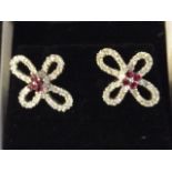 A pair of 18ct white gold, ruby and diamond earrings in the form of flowers