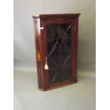 A C19th inlaid mahogany astragal glazed hanging corner display cupboard with bookwood lining and