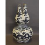 A Chinese blue and white twin spout double gourd shaped vase decorated with a dragon and clouds,