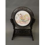 A Chinese ceramic plaque depicting a goddess sitting on a cloud, within a pierced and carved