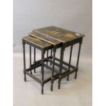 A nest of three Chinese black lacquer occasional tables with painted gilt decoration of figures