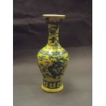 A Chinese porcelain vase with green enamel incised decoration on a yellow ground, 6 character mark