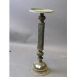 An Islamic bronze oil lamp stand in three sections, with traces of engraved decoration, possibly