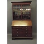 A George III mahogany fall front bureau with fitted and inlaid interior over four drawers and ogee