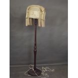 An early C20th walnut standard lamp with original tasselled parchment shade with sailing ship