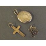 A 9ct gold crucifix pendant, a 9ct gold locket, and another 9ct gold pendant in the form of the
