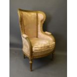 A C19th French carved giltwood wing back armchair on fluted supports