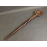 A carved wooden ladle, 23'' long