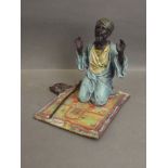 A cold painted bronze figure of a Moor on a prayer rug, impressed 'B' to base, 5'' high