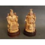 Two carved ivory figures of an emperor and empress seated, on shaped wood bases, 6'' high