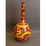 A Chinese long necked bottle shaped vase with raised dragon decoration on a yellow ground and