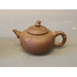 A Chinese Yixing pottery teapot with relief bamboo decoration, stamp mark to base, 6'' long