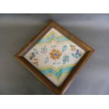 An antique Hispano-Moresque ceramic tile with floral decoration, in an oak frame, 9½'' square,