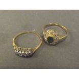An 18ct gold, emerald and diamond dress ring, and another three stone diamond ring