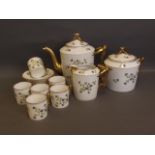 An English porcelain tea set painted with small blue flowers and leaves, and gilt highlights to