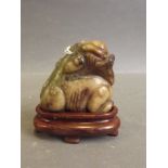 A small Chinese carved jade pendant in the form of a dragon, on a later wood stand, 2'' long