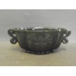 A Chinese spinach jade twin handled cup with floral decoration, 5½'' wide