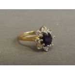 An 18ct gold ring with central set sapphire encircled by eight diamonds, size N