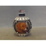 A Peking glass snuff bottle decorated with dogs, with raised decoration to sides, 2½'' high