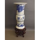 A Chinese porcelain Gu shaped vase with blue and white decoration, raised on a carved hardwood