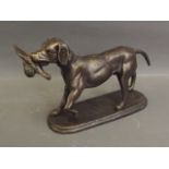A patinated cast metal door stop in the form of a gun dog with game bird, 9'' long