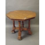 A Victorian oak centre table, with octagonal top on four turned and carved supports united by a