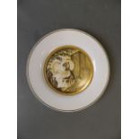 A Russian porcelain plate with gilt border and painted decoration of a girl and gentleman with