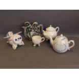 A Chinese pierced and shaped teapot, an aeroplane teapot, an 'American Revolution' teapot, and a