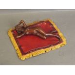 A cold painted bronze figure of a nude lady laying on a fringed rug, signed 'Bergm', 7½'' long