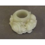A large jade archers ring carved with a tortoise, dragon and bat, 2'' wide