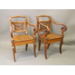 A pair of Ottoman walnut elbow chairs with pierced backs, scrolled arms, and solid seats on a frieze