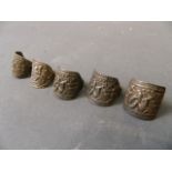 Five Chinese white metal rings with repoussé decoration
