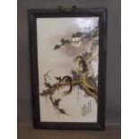 A large Chinese ceramic panel within a carved wood frame, decorated with calligraphy and squirrels