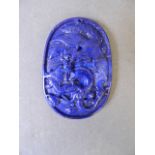 A Chinese oval carved lapis lazuli pendant with phoenix and dragon decoration, 2'' x 1½''