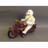 A novelty cast metal figure of the Michelin Man riding a motorcycle, 8½'' long