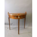 A French brass inlaid mahogany demi-lune two drawer pier table with brass mounts and pierced upper