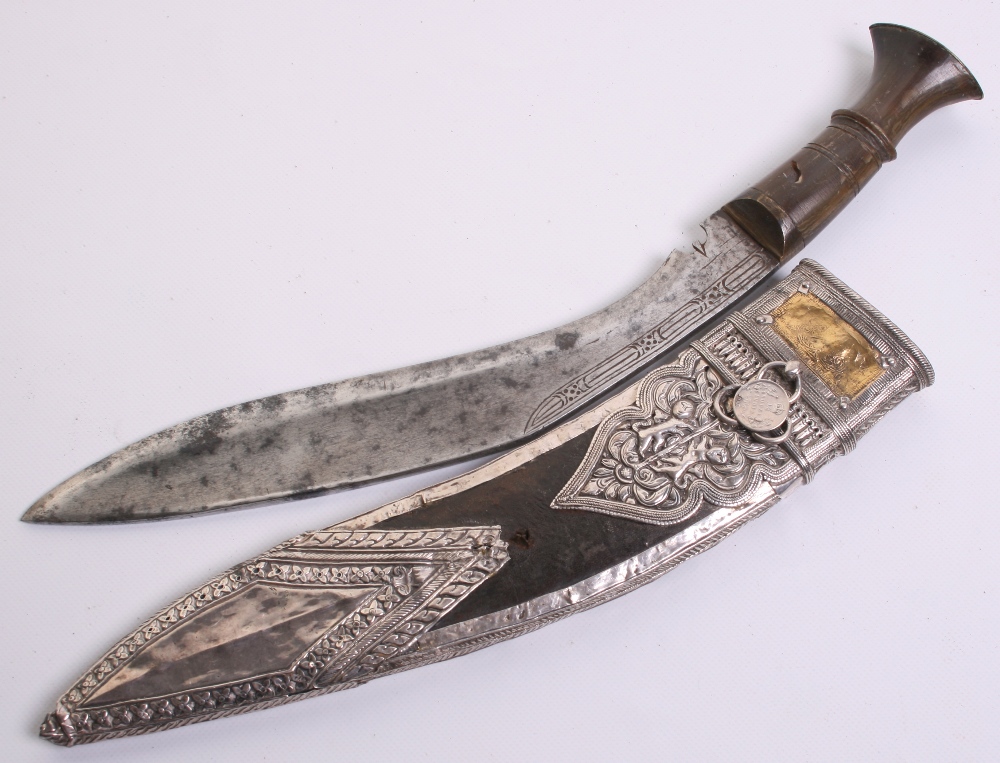 Indian kukri, blade 11", horn grip with brass mounts. In its silver mounted sheath with gold panel