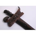 Balinese Kris with wavy watered steel blade. Carved wood handle and scabbard. 65 ½ cm in length,