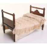 Wooden dolls bed, with some original bedding, bolster and mattress, 18 ¾” (48cm) tall,