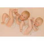 Pair of Heubach bisque piano babies, German circa 1910, the well moulded babies both laying on their