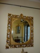 Oval wall mirror in rectangular carved g